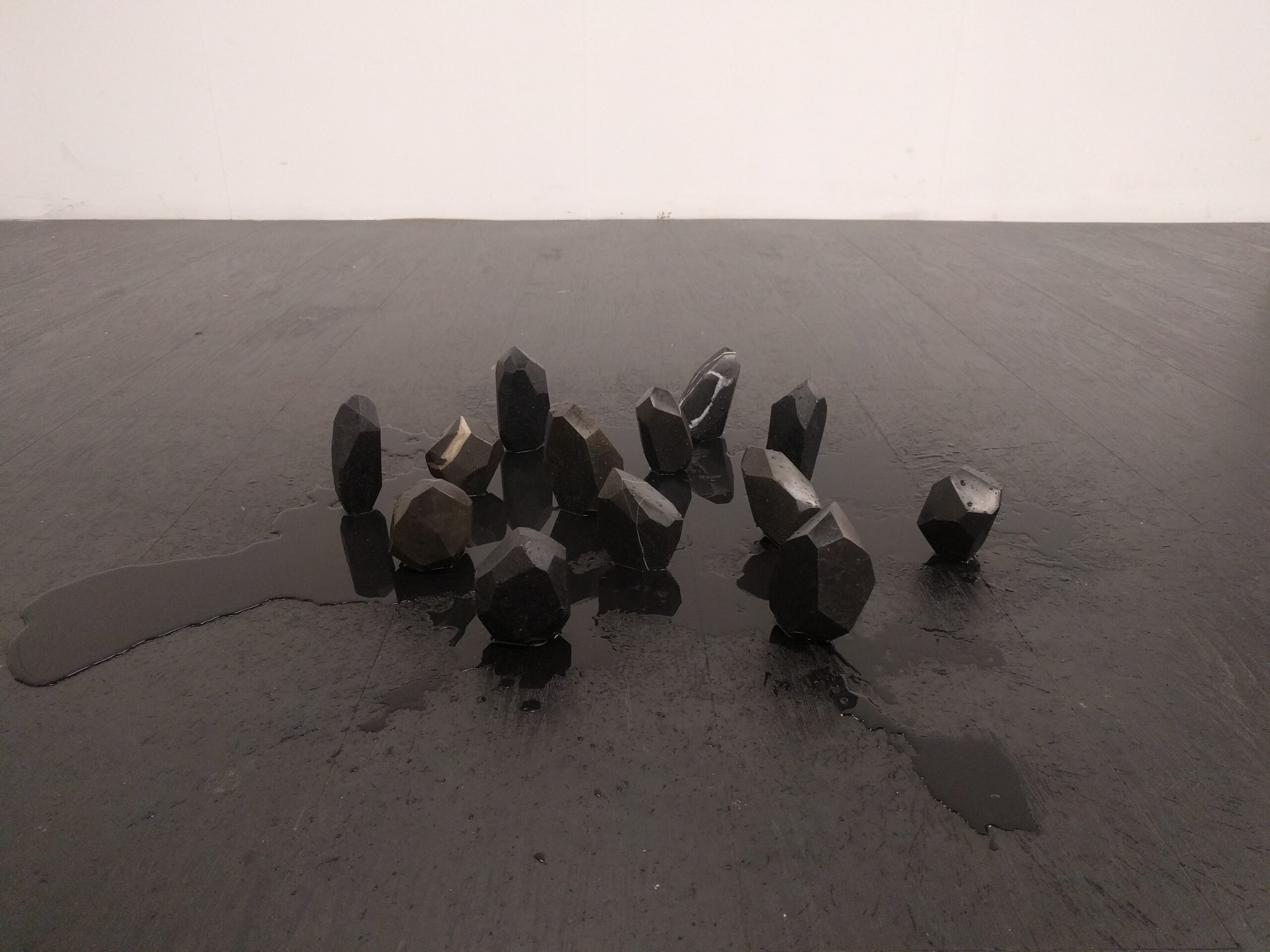 Genesi 2.0, 2018 Pietre di fiume, granito nero, olio, acqua 80 x 80 x 15 cm - Marta Longa - courtesy of the arist